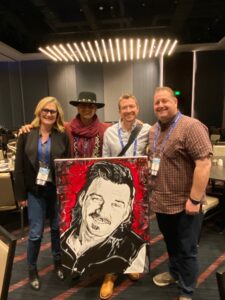 About to visit the Neal Agency and celebrating a weekend Morgan Wallen date (the venue’s highest grossing ever), Tacoma (WA) Dome marketers bought this painting to present to Wallen via his agent in Nashville. From left are Tacoma’s Tammi Bryant; Sergio Gutierrez, the artist; Rob Herbert, Sergio’s manager; and Tacoma’s Jeff Bowen.