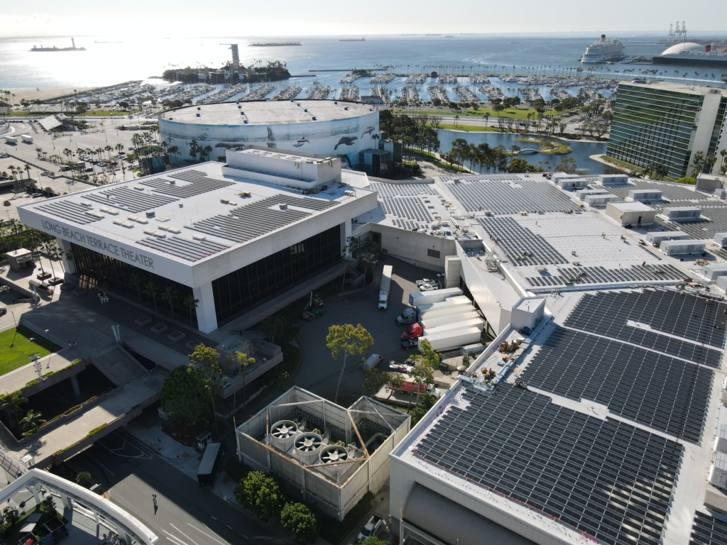 Aerial view of solar panels on roof of convention center with water in the distance
