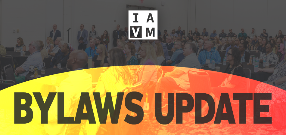 IAVM logo and "Bylaws Update" screened over photo of group of people at IAVM event